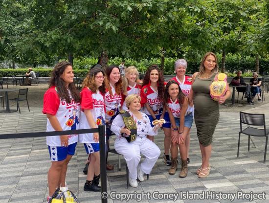 Melody Andorfer (front) received her victory belt for the 1972 contest at the weigh-in ceremony for the 2021 Nathan's Hot Dog Eating Contest, July 2, 2021. Photo courtesy of Nathan's Famous.